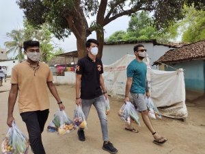 जरूरमन्दों  को राशन किट पहुँचा रहे युवा गणेश उत्सव समिति के सदस्य